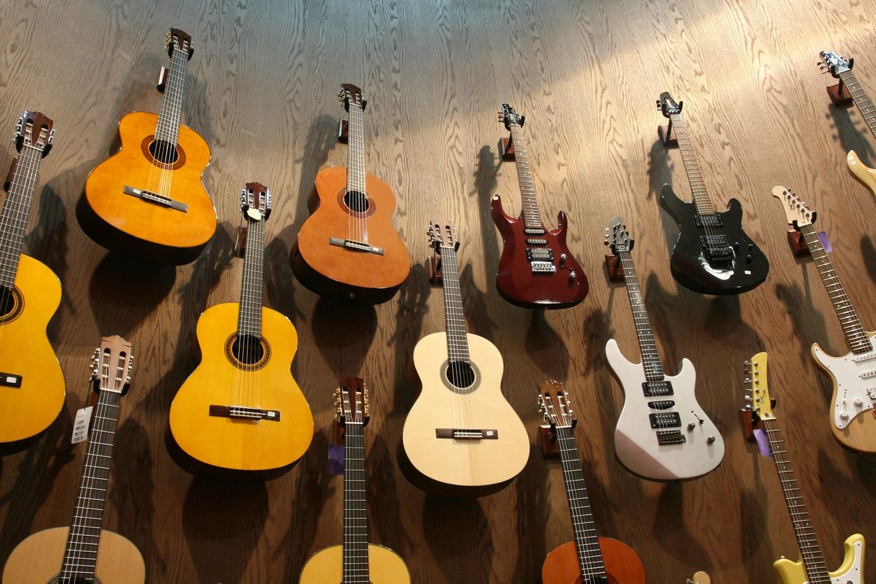 Range of guitars hanging on a wall ready for a group music lesson in Heidelberg