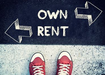 sneakered feet standing at a ground sign with arrows pointing left to rent and right to own