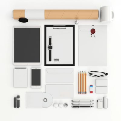 White background with a mug, mailing tube, large tablet, pens, pencils, pads , envelopes and magnets
