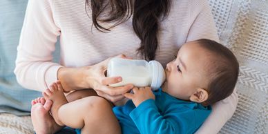 Woman feeding baby with a bottle of milk