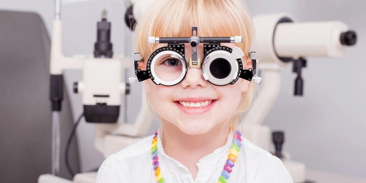 little girl wearing diagnostic eyeglass apparatus