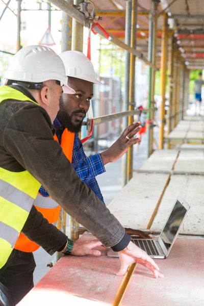 two construction workers looking at laptop computer