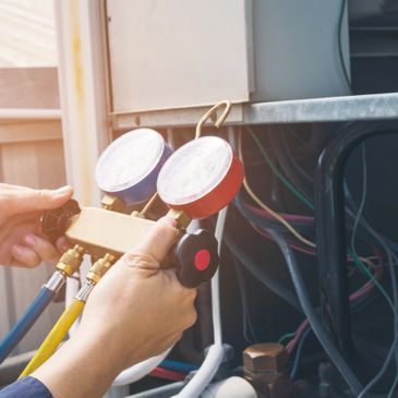 A/C technician testing the pressures on an A/C unit. 