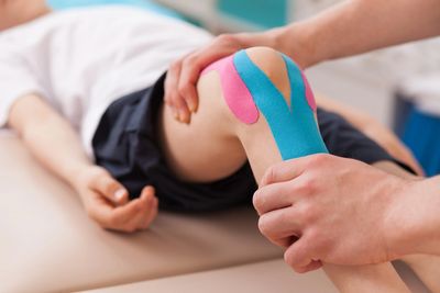  a child wearing KT tape for his knee
