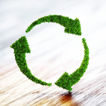 Three arrows appear to be make of grass forming a circle to represent the recycling symbol