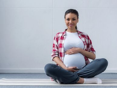 Sitted pregnant woman holding her baby bump