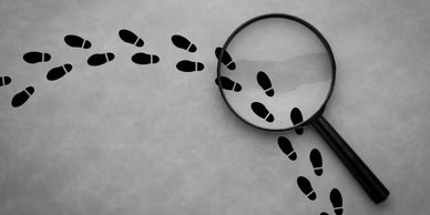 magnifying glass and footsteps depicting work in the investigative industry