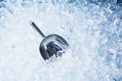 An ice scooper in a pile of ice.