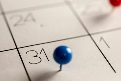 A pin in a date on a calendar.