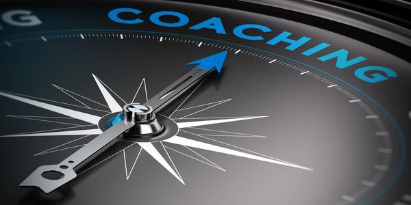 A compass with the words coaching where North points. 