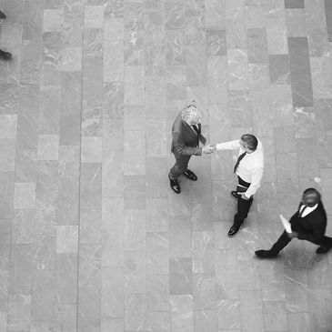 Aerial photo of random office people in the street. Two are shaking hands.