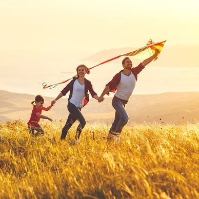 Happy healthy family running through field 