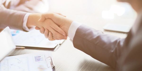 Man and woman shaking hands at a business meeting.