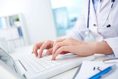 Dr. typing on laptop