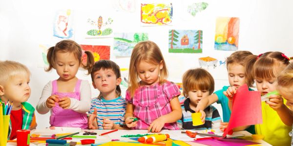 Young kids in preschool working on a craft at a table