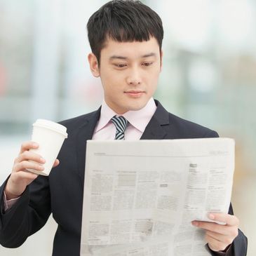 A business professional reads the newspaper.