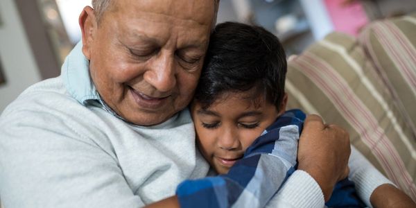 Older man hugging his grandson