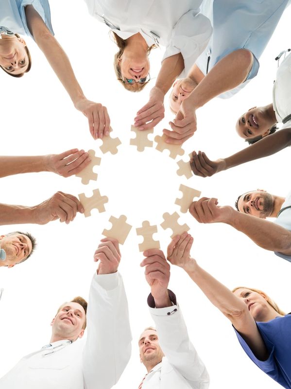 A group of people standing in a circle with jigsaw puzzle pieces in hands