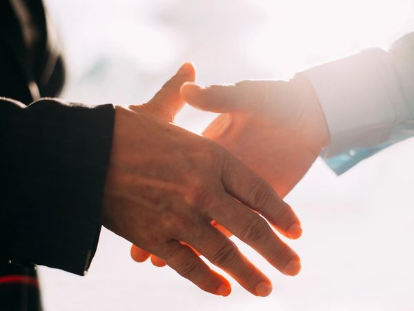 Two people shaking hands over an agreement.