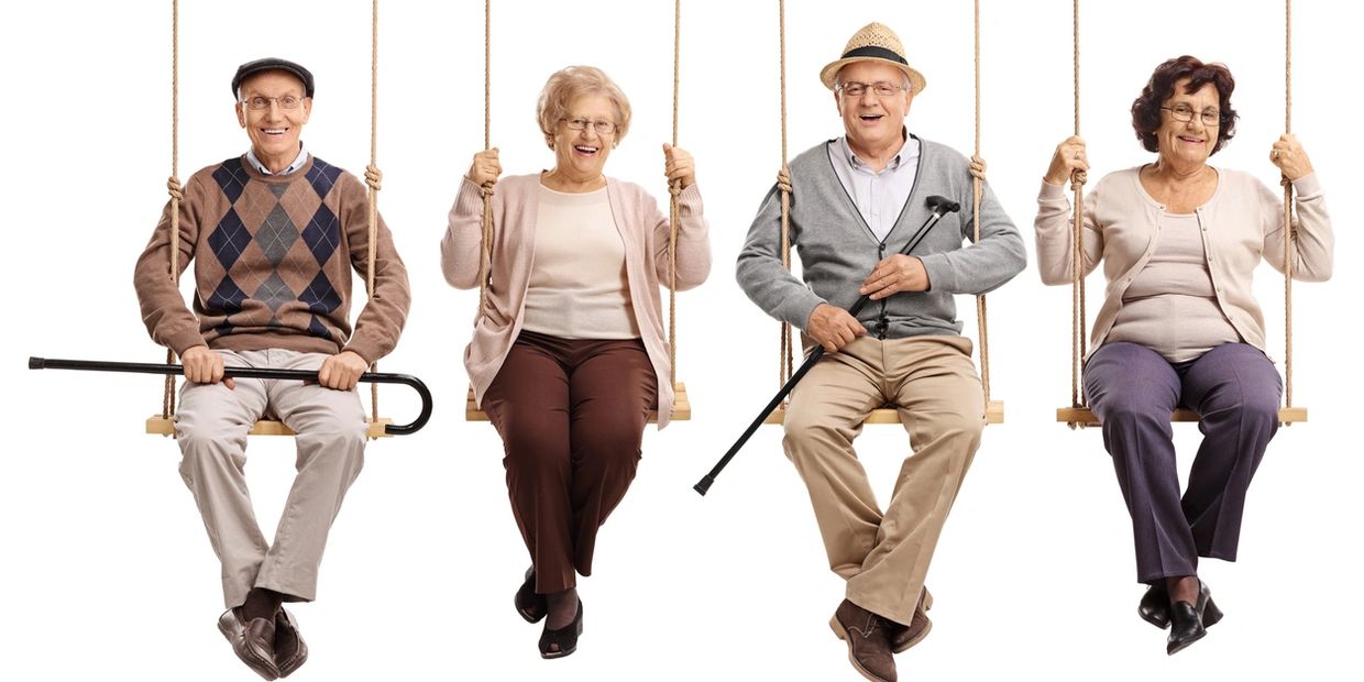 four seniors sitting on swings smiling and enjoying themselves