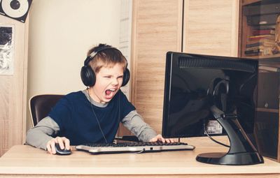 Young boy yelling at his computer.