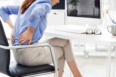Lower back pain treated with physiotherapy at work by the Home Physios 