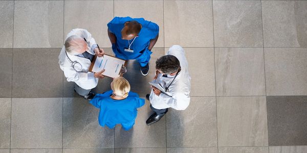 Photo of doctors conferring over a clipboard