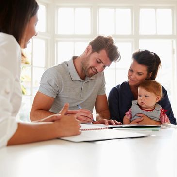 A young family with a Insurance broker. They are signing forms regarding their insurance.