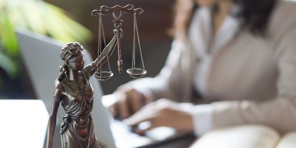 Professional female working with a statue of lady justice sitting on a desk