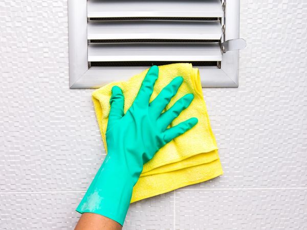 a woman cleaning a vent