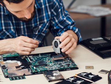 A meticulous technician expertly services a laptop, demonstrating precision in hardware repair and maintenance.