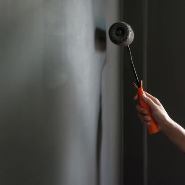 a wall being painted black by roller