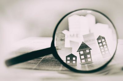 Through a magnifying glass, one could see houses constructed from paper.
