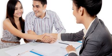 Young adult man and woman shaking hands with an insurance agent