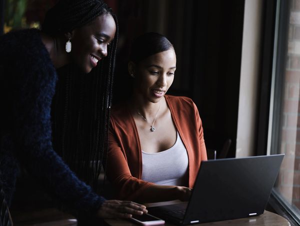 two women watching something on a laptop.