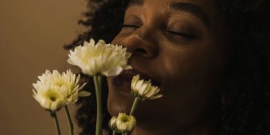 A woman smelling a bouquet of flowers
