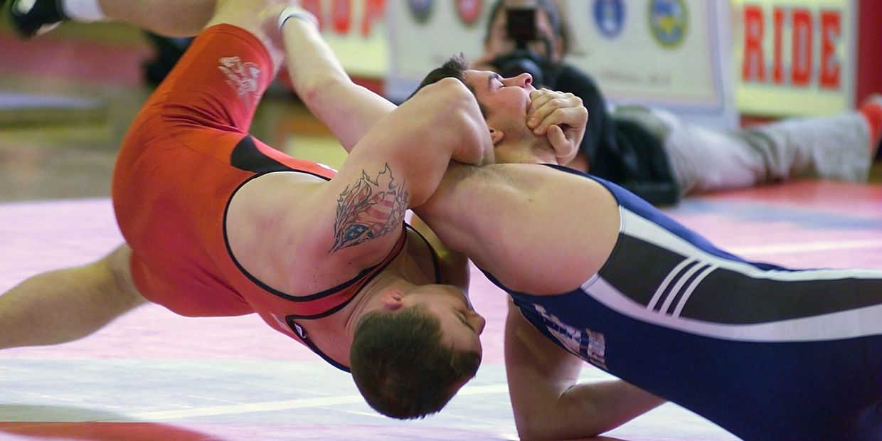 Wrestlers grappling each other on the ground