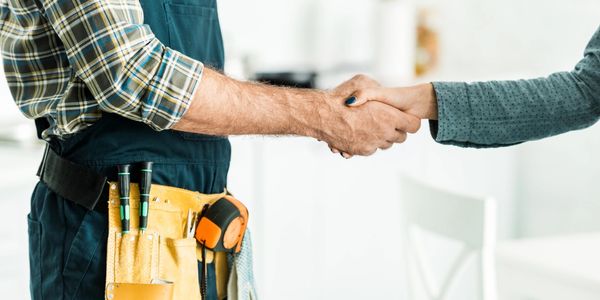 Handyman shaking hands with a woman