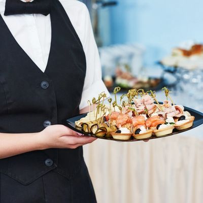 A waiter handing out canapes and finger food at an event