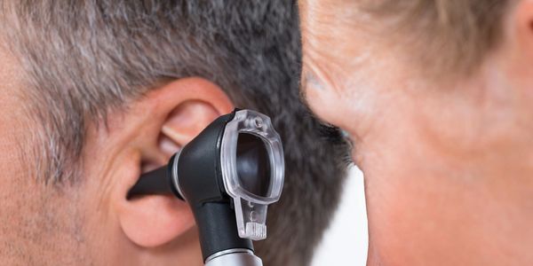 A doctor looking into a ear.