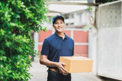 Delivery man holding a box for delivery.