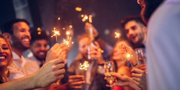 Group of people partying having fun holding sparklers. Intuitive Readings done at parties