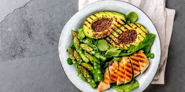 Keto meal, diet food avocado salmon salad asparagus. 