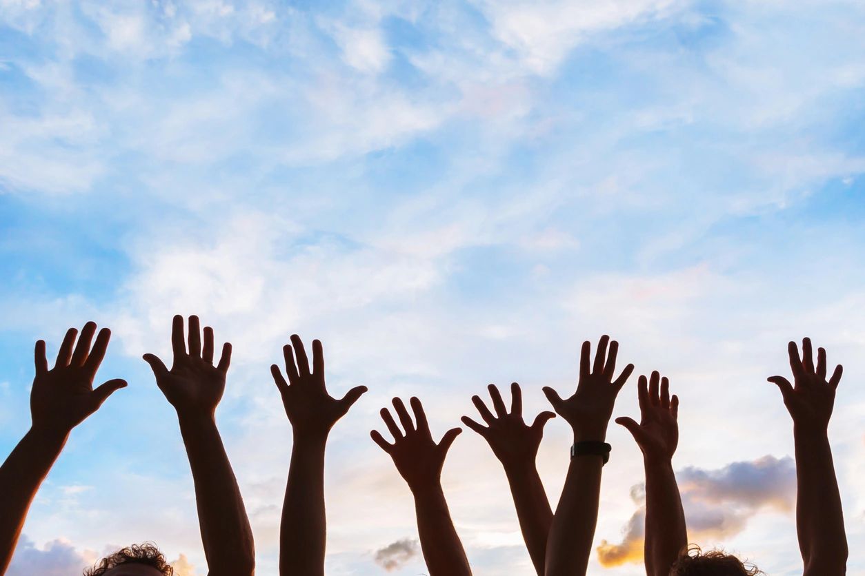 Hands reaching out in the air for bereavement support.