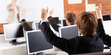 Children in a classroom behind computer screens