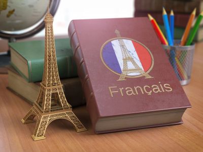 French language book and Eiffel Tower model on a desk.