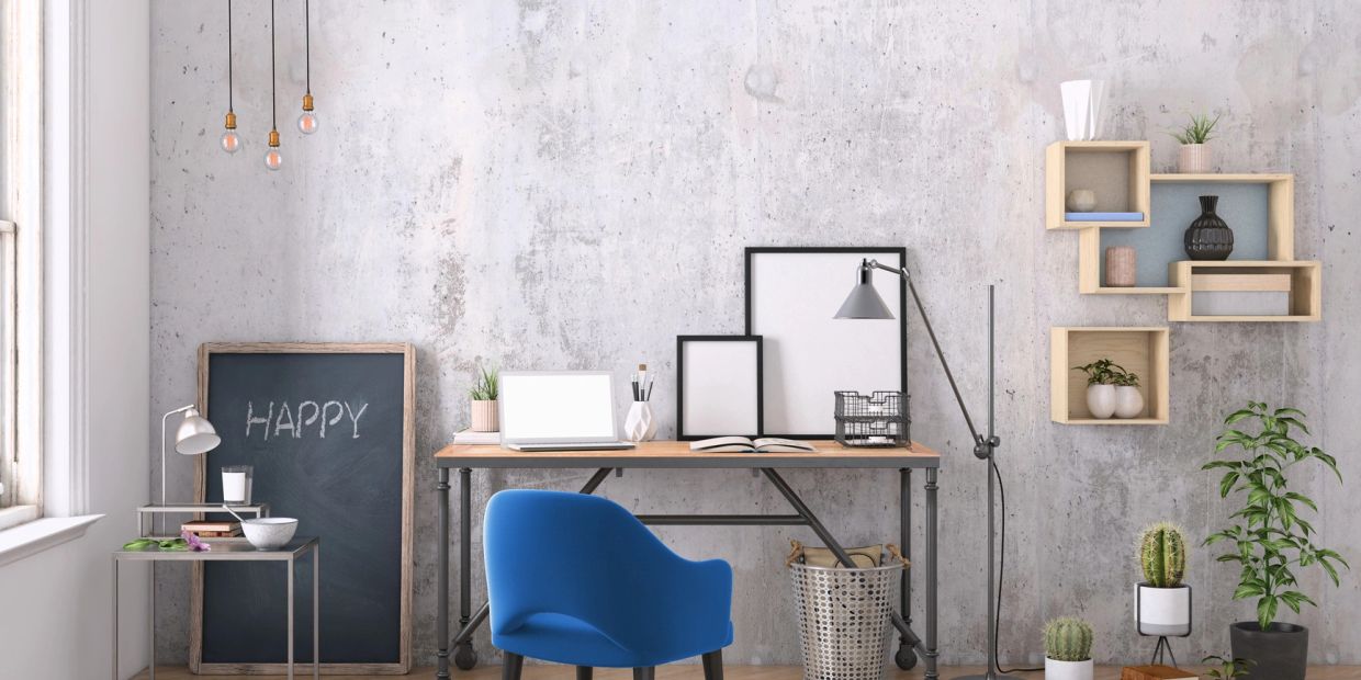 Modern workspace with a blue chair, wooden desk, and decorative plants against a textured wall.