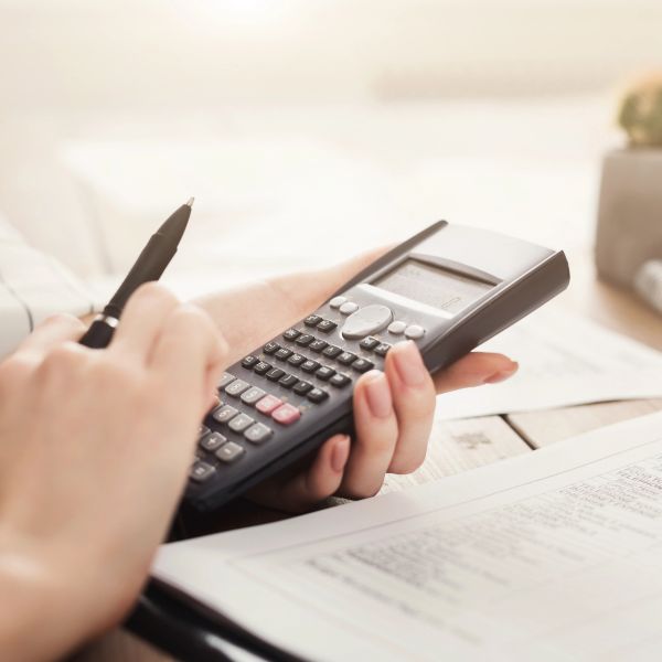 Person using a calculator and pen for calculations.