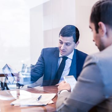 Two businessmen discussing documents in a modern office.