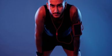 Athlete resting after an intense workout, wearing earbuds and fitness gear.